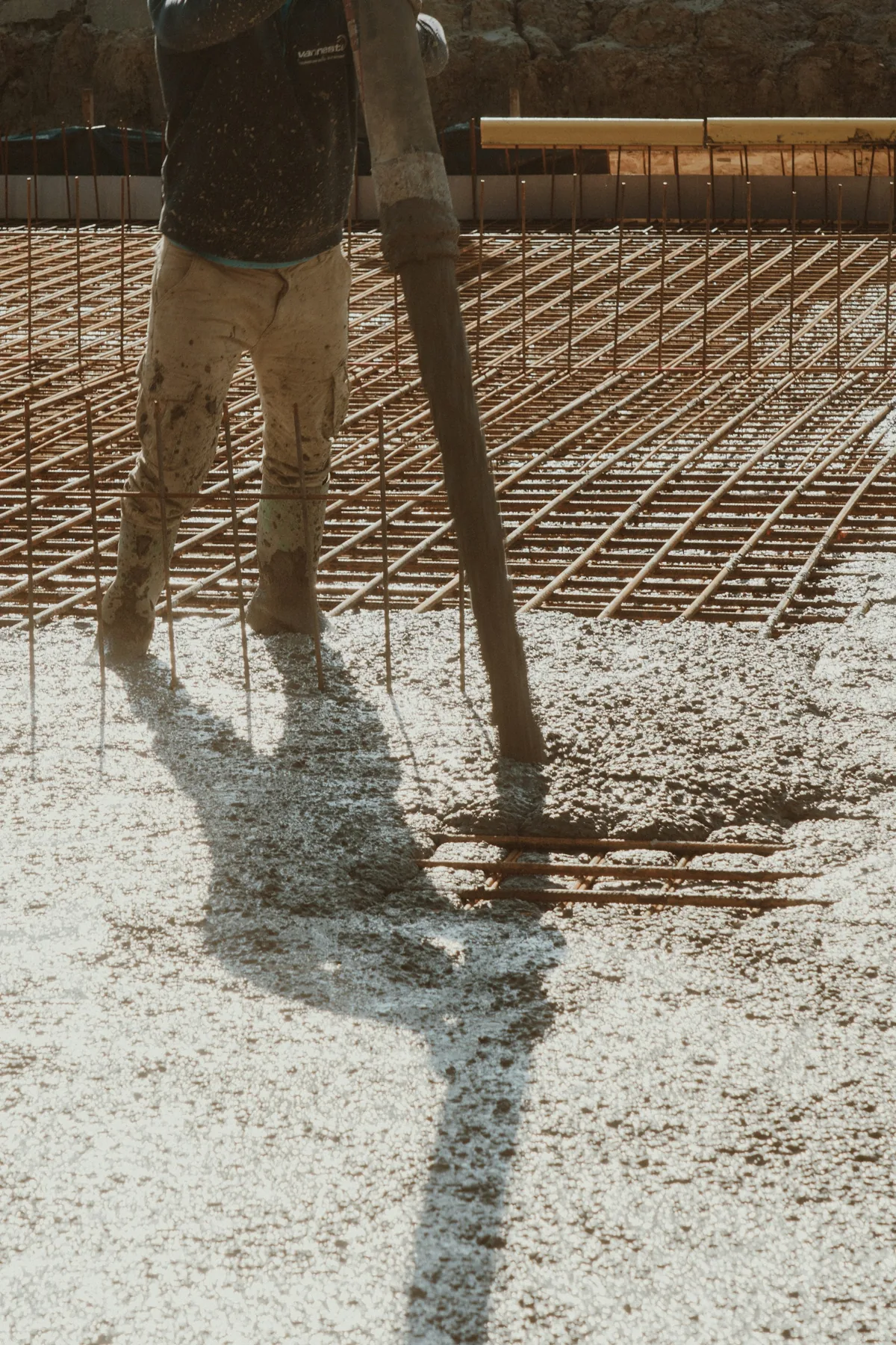 Fresh concrete being placed over rebar on a reinforced slab