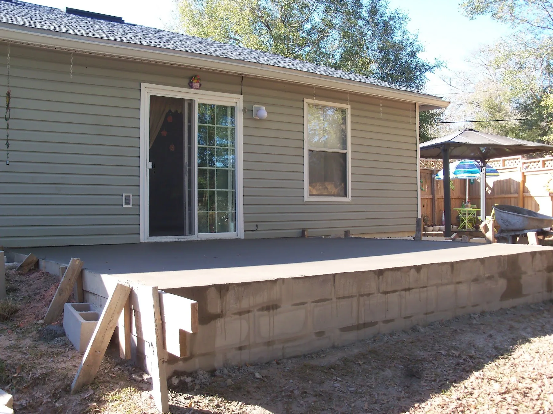 Block stem wall carrying a new raised patio slab behind a home, built by L&N
