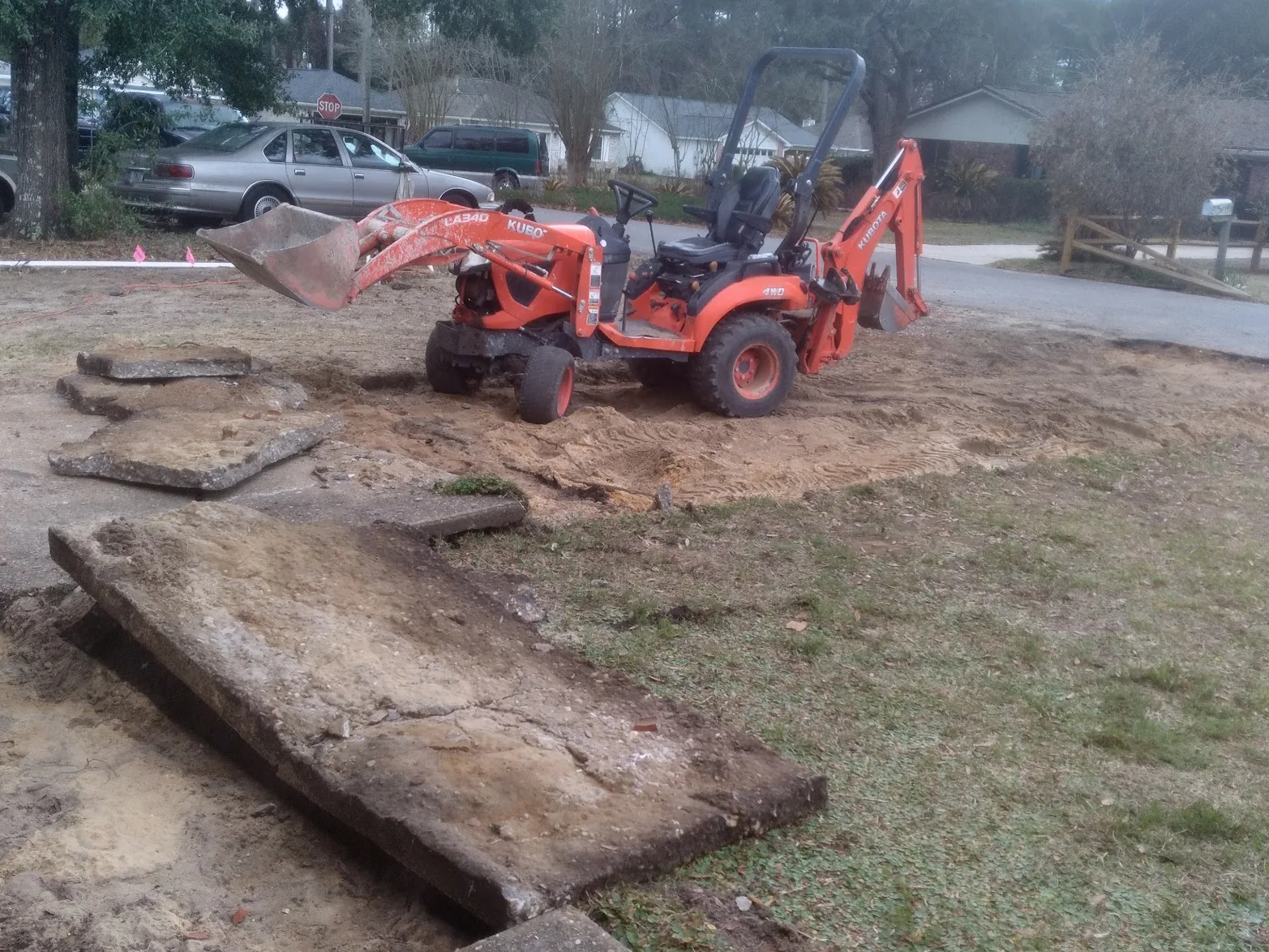 L&N tractor on a residential lot with an old driveway torn out and the ground graded